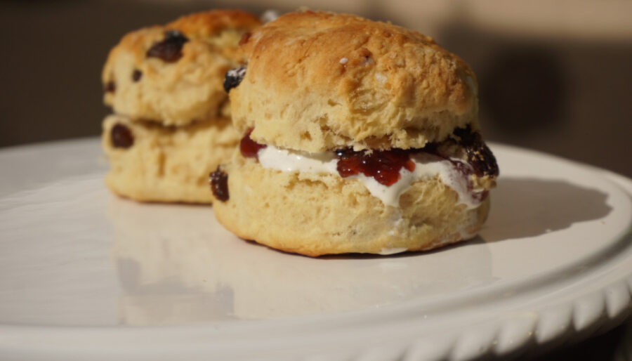 Image of two scones with cream and jam on a plate