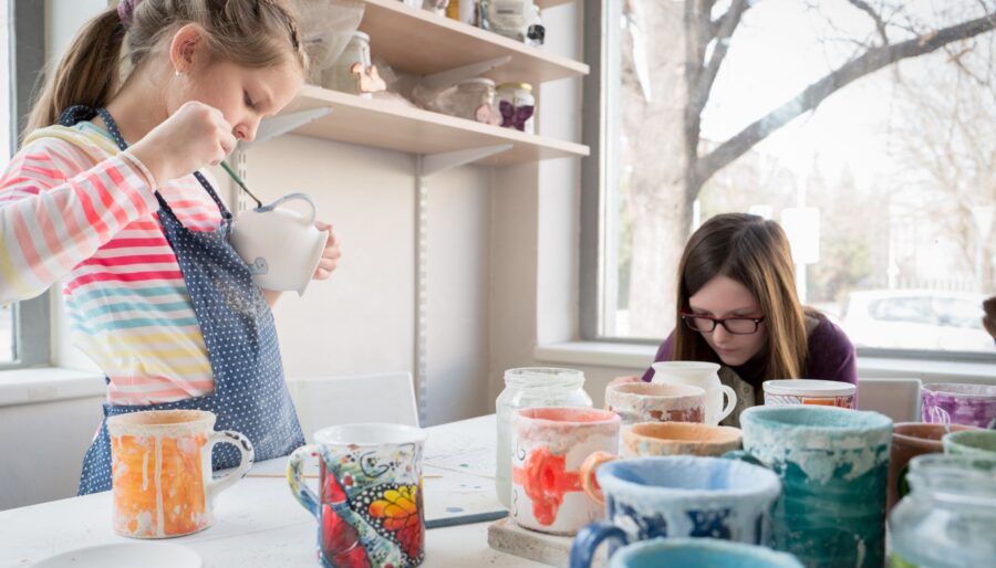 Image of two girls pottery painting.