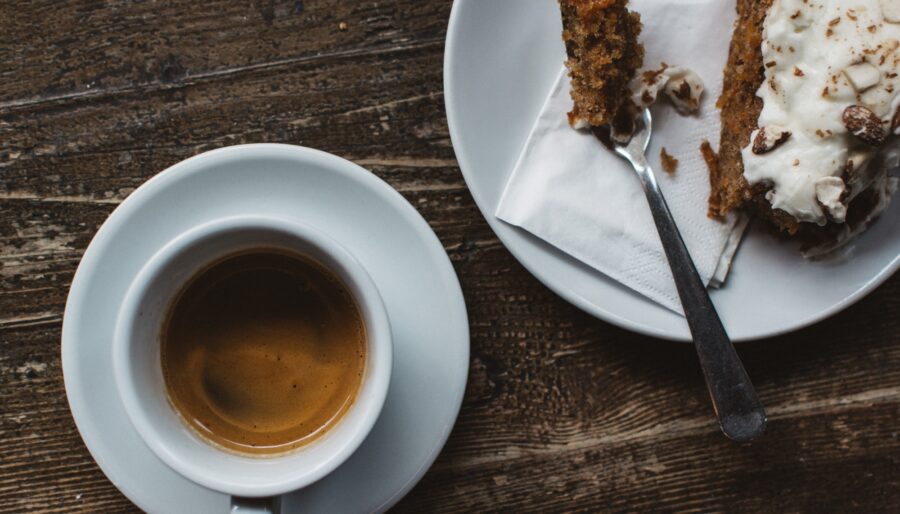 Image of a cup of coffee and a slice of cake with a fork
